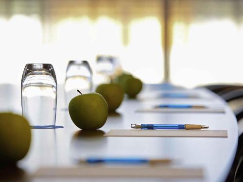 a table with an apple and a pen on it at Mercure Kooindah Waters Central Coast in Wyong