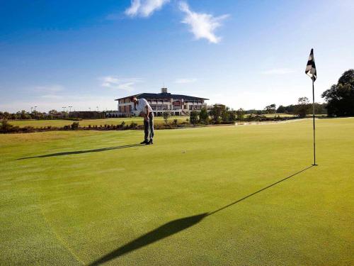 a man is playing golf on a golf course at Mercure Kooindah Waters Central Coast in Wyong