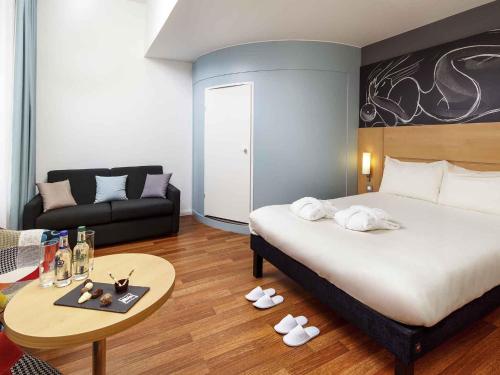 a bedroom with a bed and a table and a couch at ibis Edinburgh Centre South Bridge – Royal Mile in Edinburgh