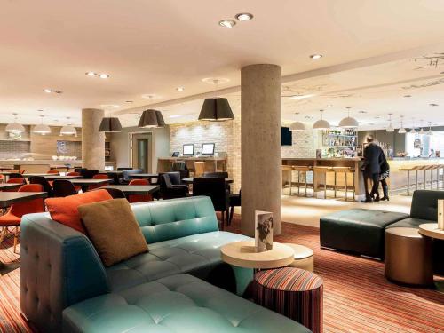 a lobby with a couch and tables and a bar at ibis Edinburgh Centre South Bridge – Royal Mile in Edinburgh