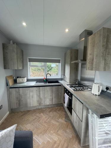 a large kitchen with a sink and a stove at Sutton Fields Chalet in Preston on the Hill