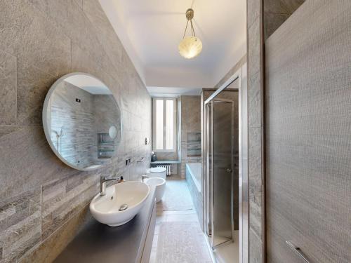 een badkamer met een wastafel en een spiegel bij Wonderful downtown apartment-HD NETFLIX, KING-SIZE BED, two minutes' walk from metro in Milaan