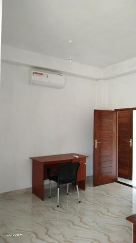 a desk with a chair in a room with a door at River way in Ratnapura