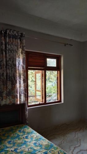 a bedroom with a bed and a window at River way in Ratnapura