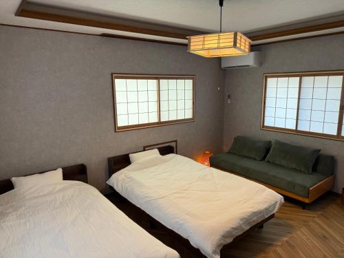 un dormitorio con dos camas y un sofá en Seiran静蘭, en Takayama