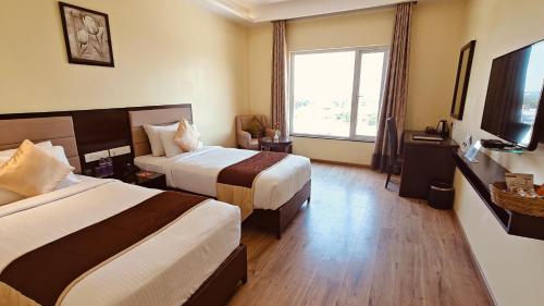 Una televisión o centro de entretenimiento en ASR Parklane, A Bergamont Hotel - Hosur
