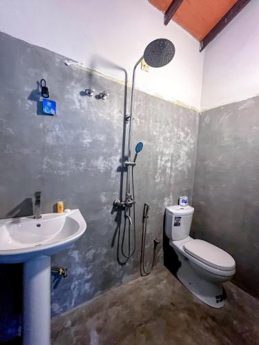 a bathroom with a shower and a toilet and a sink at The Garden in Ahangama