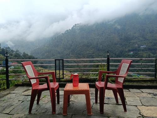 three chairs and a table with a view of a mountain at Global home stay in Sari