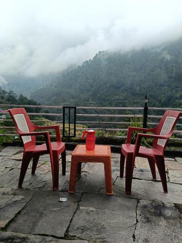 three chairs and a table with a view of a mountain at Global home stay in Sari