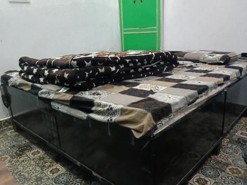 a table with a checkered blanket on top of it at Global home stay in Sari