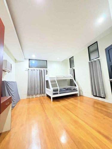 a bedroom with a bed in a room with a wooden floor at Malibu Lanang SMX convention nearby Full house in Davao City