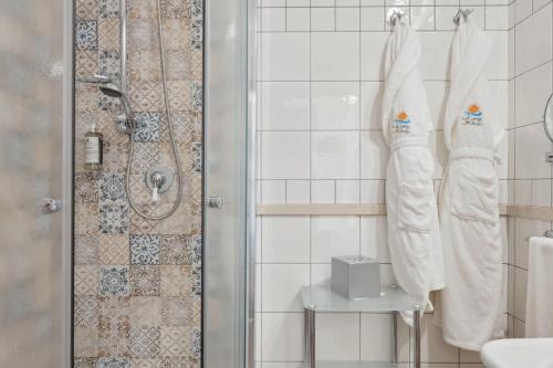a bathroom with white towels and a shower at Hotel La Corte Del Sole in Noto