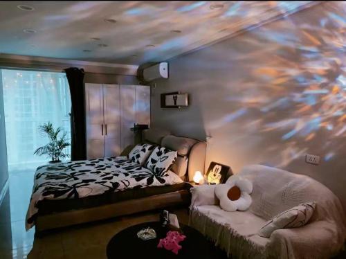 a bedroom with a bed and a teddy bear on a couch at Aisen Apartment Huainan Wanda Plaza Near City Center in Huainan