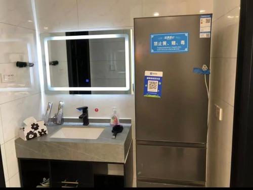 a bathroom with a sink and a mirror and a shower at Aisen Apartment Huainan Wanda Plaza Near City Center in Huainan