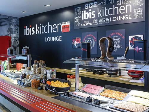 a fast food restaurant with a buffet of food at Hotel Ibis Lisboa Parque das Nações in Lisbon