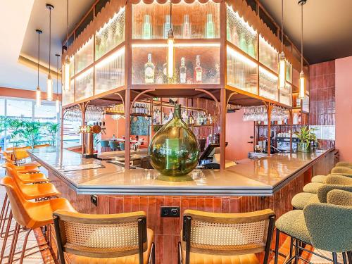 a bar with chairs and a large glass vase at Hotel Ibis Lisboa Parque das Nações in Lisbon