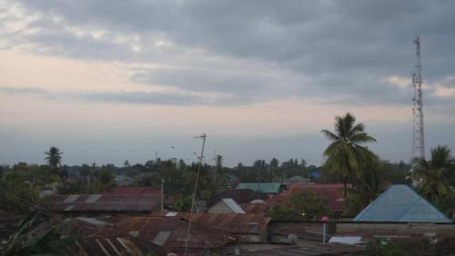 a view of a city with roofs and palm trees at Dhow House in Bagamoyo