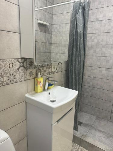 a bathroom with a white sink and a shower at Гагарина 119 in Dnipro