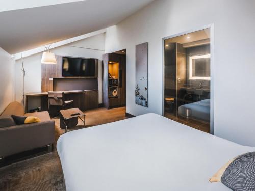 a bedroom with a bed and a living room at Novotel Toulouse Centre Wilson in Toulouse