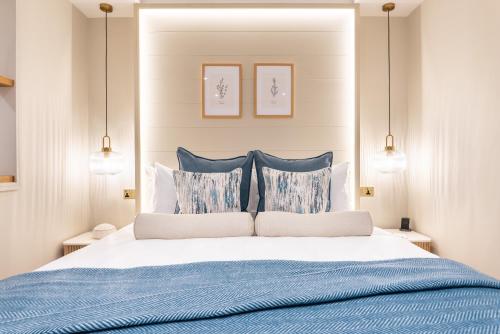 a bedroom with a blue and white bed with pillows at Elements Suites in Middlezoy