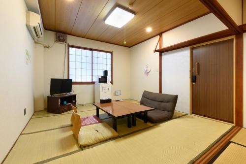 un soggiorno con un tavolo e una sedia di OYO Ryokan Hamanako no Yado Kosai - Vacation STAY 38825v a Kosai