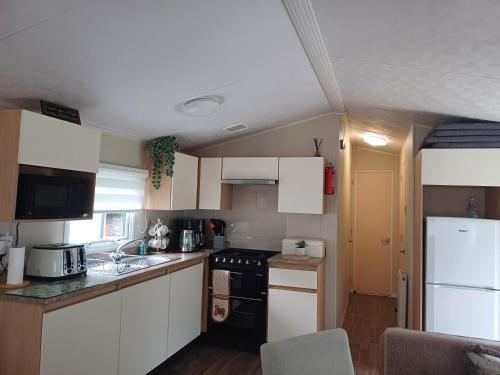 Haggerston Castle LAKEFIELD 12 - ENTERTAINMENT PASSES NOT INCLUDEDにあるキッチンまたは簡易キッチン