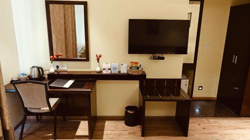 Una televisión o centro de entretenimiento en ASR Parklane, A Bergamont Hotel - Hosur