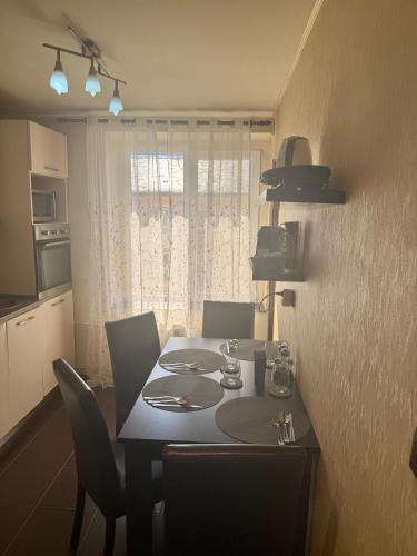 a dining table and chairs in a kitchen with a window at Apartament Casa Bella in Craiova