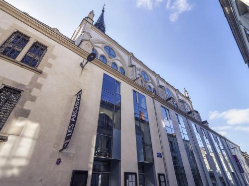 a building with glass windows on the side of it at Mercure Poitiers Centre in Poitiers