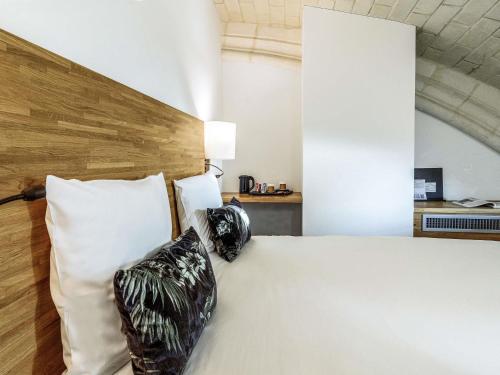 a bedroom with a bed with two pillows on it at Mercure Poitiers Centre in Poitiers