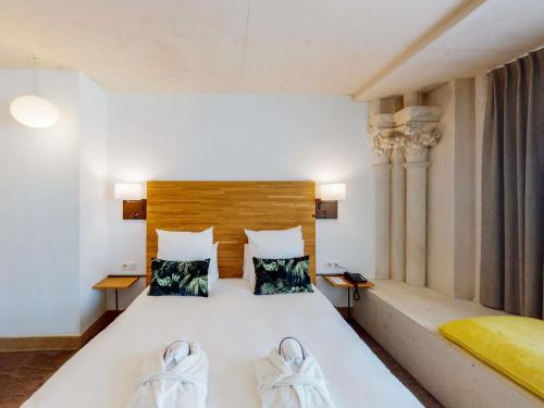 a bedroom with a large white bed with two towels at Mercure Poitiers Centre in Poitiers