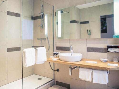 a bathroom with a sink and a shower at Mercure Poitiers Centre in Poitiers