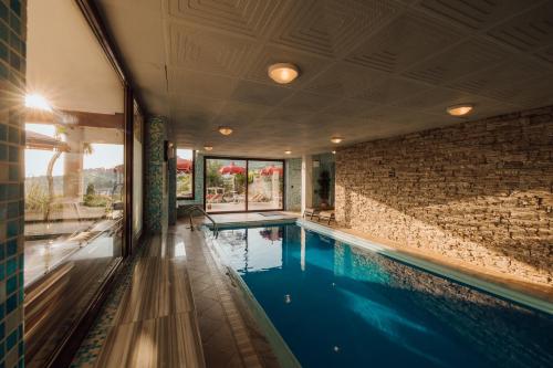 a swimming pool in a house with a brick wall at Villa Bellevue Portoroz-Portorose in Portorož