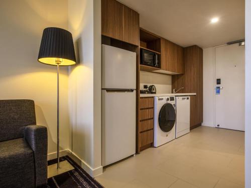 a kitchen with a refrigerator and a washing machine at Mantra Gladstone in Gladstone