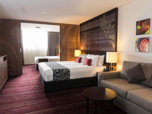 a hotel room with a bed and a couch at Mantra Gladstone in Gladstone
