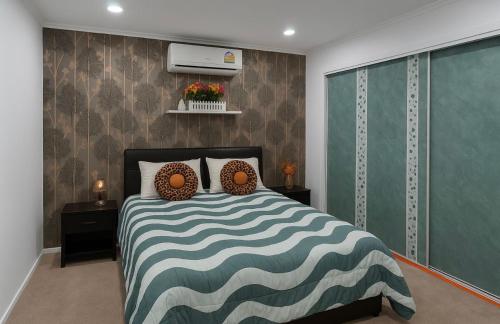 a bedroom with a bed with a blue and white comforter at Private Bedroom and Large Deck Separate Entrance in Auckland