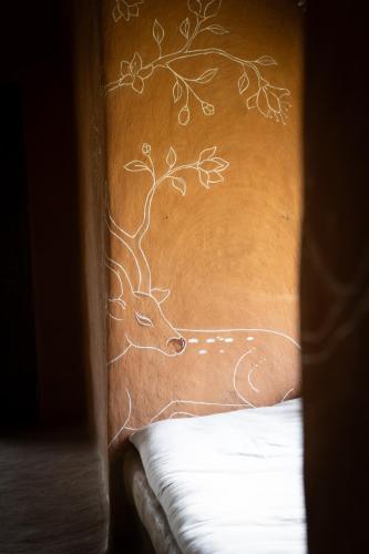 a wall with a drawing of a cow on it at The Mudhouse Marayoor in Munnar