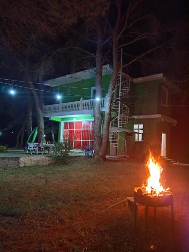 Darëzeza e ReVjosa River Rooms的夜晚在房子前面的火