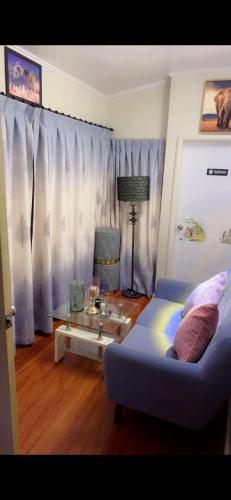 a bedroom with a blue bed and a glass table at Private Bedroom and Large Deck Separate Entrance in Auckland