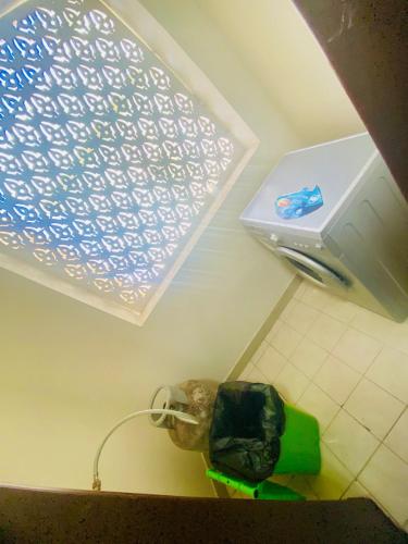 a small refrigerator in a room with a wall at Rest-Inn Furnished Apartments ريست-ان للشقق المفروشة in Muscat