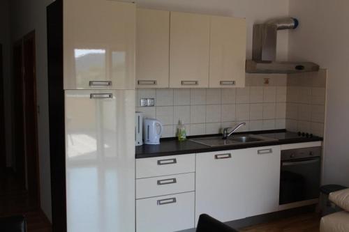 a kitchen with a white refrigerator and a sink at Apartment Jure in Primošten