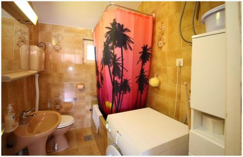 a bathroom with a sink and a toilet and a shower curtain at Apartment Josip in Primošten