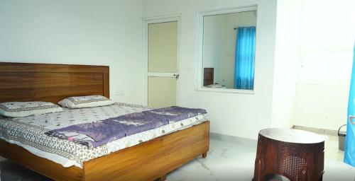 a bedroom with a wooden bed and a mirror at Hari Kamal Guest House And Swimming Pool in Dhānd