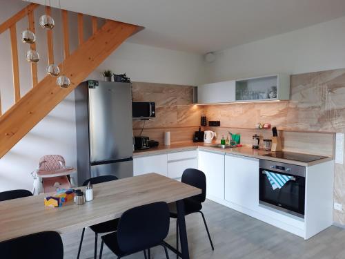 a kitchen with white cabinets and a wooden table at Pod hrází & Sedmé nebe in Staré Splavy
