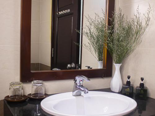 a bathroom sink with a mirror and a white sink at Sunview Beach Hotel Danang in Da Nang