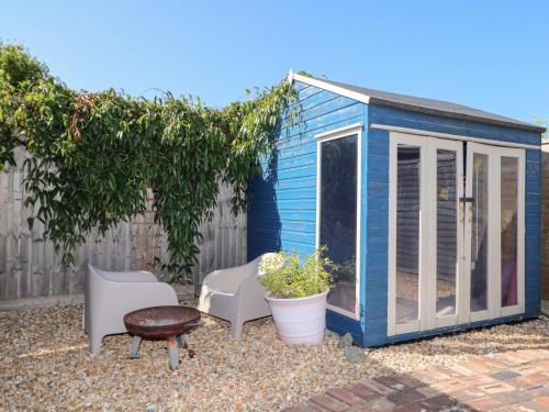 a blue tiny house with chairs and a table at Harbour Road Quirky Beach Railway Carriages in Bognor Regis