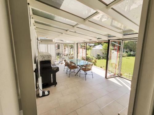 a conservatory with a table and chairs on a patio at VK - VBD - Zürich Airport - Homestay - Villa Bassersdorf in Bassersdorf