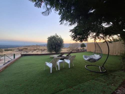 a group of chairs sitting on a lawn at דובדבן בגולן in Had Nes