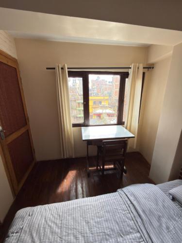 a bedroom with a desk in front of a window at Cityview Guest House in Kathmandu