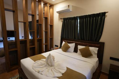 a bedroom with a bed with white sheets and pillows at Hotel Lotus in Candolim